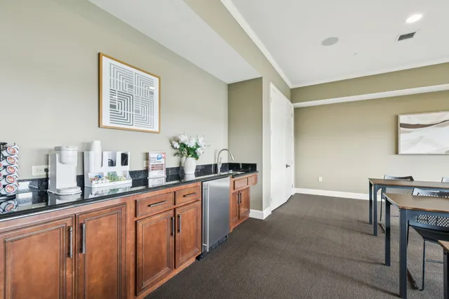 a large kitchen with granite countertop lots of counter space and stainless steel appliances