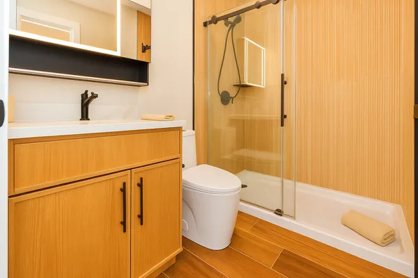 a bathroom with a sink a toilet and shower