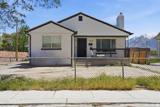 7879 Oak Street Midvale, UT 84047 - Photo 28 of 32 Single-story property featuring a front porch with dark railings, a white brick facade, and dark trim