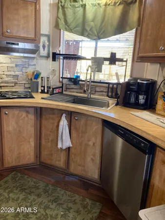 a kitchen with granite countertop a sink a stove and wooden cabinets