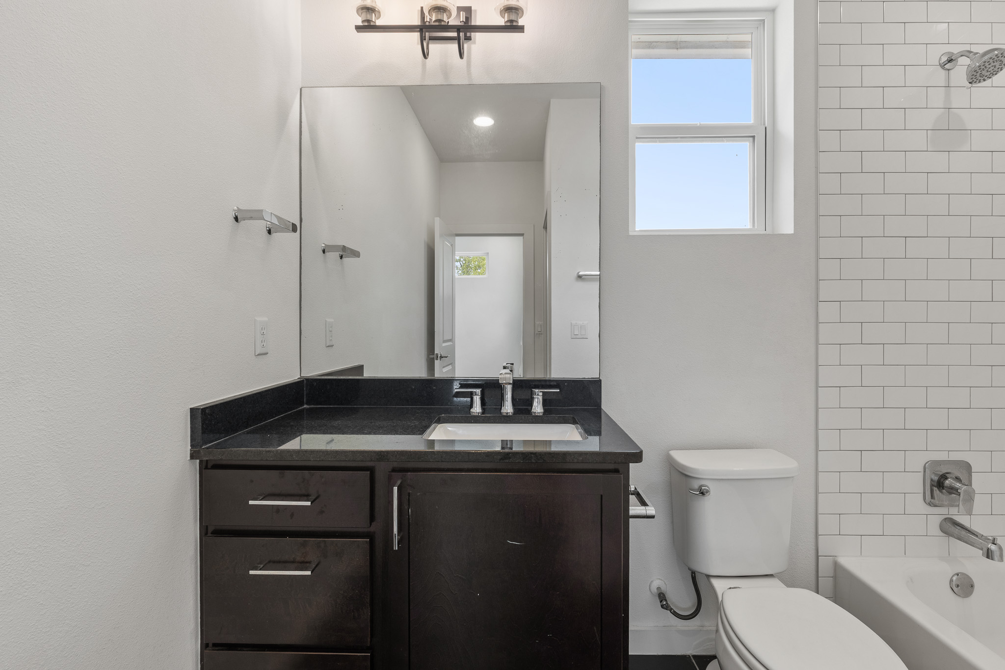 2604 Wheless Lane, Unit 1 Austin, TX 78723 - Photo 30 of 38 Dark wood vanity with black countertop adds warmth and sophistication to the space.