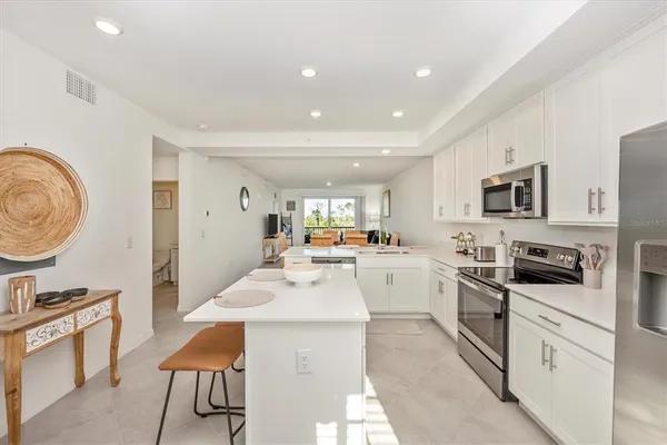 a kitchen with white cabinets sink and stainless steel appliances