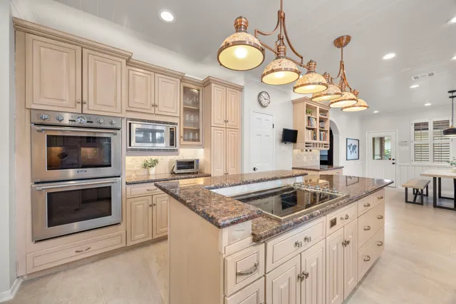 a kitchen with stainless steel appliances granite countertop a sink a stove and a refrigerator