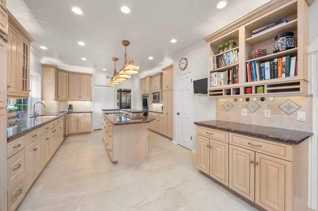 a kitchen with granite countertop a sink and white cabinets