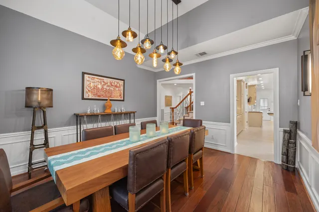 a dining room with furniture a chandelier and wooden floor