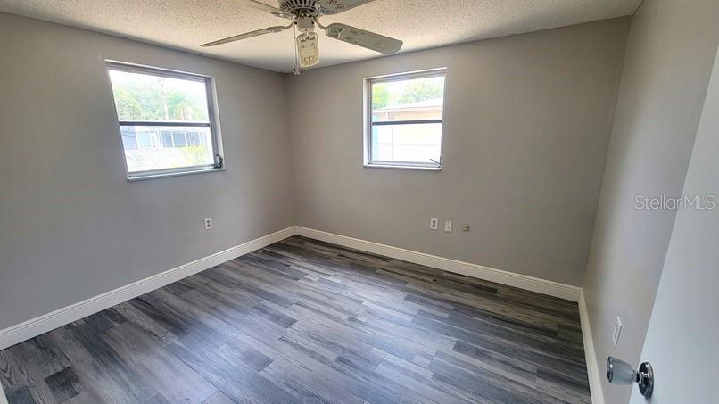9202 Suffolk Lane Port Richey, FL 34668 - Photo 12 of 20 a view of an empty room with wooden floor and a window