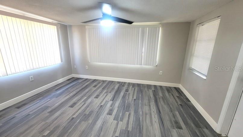 9202 Suffolk Lane Port Richey, FL 34668 - Photo 14 of 20 an empty room with wooden floor and windows