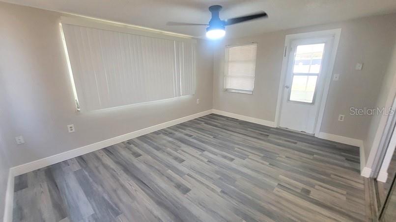 9202 Suffolk Lane Port Richey, FL 34668 - Photo 15 of 20 an empty room with wooden floor cabinet and windows