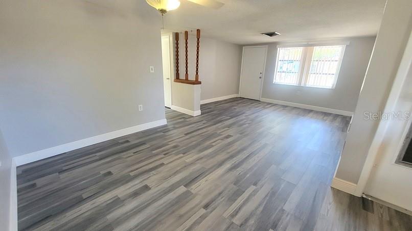 9202 Suffolk Lane Port Richey, FL 34668 - Photo 2 of 20 an empty room with wooden floor and windows