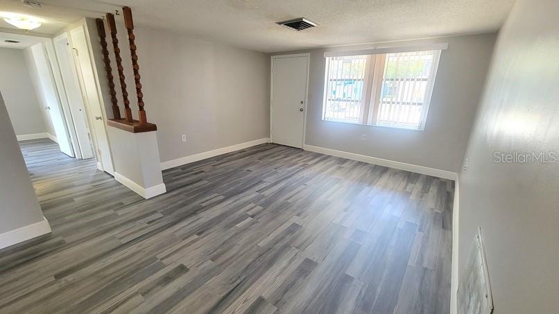 9202 Suffolk Lane Port Richey, FL 34668 - Photo 3 of 20 an empty room with wooden floor and entrance
