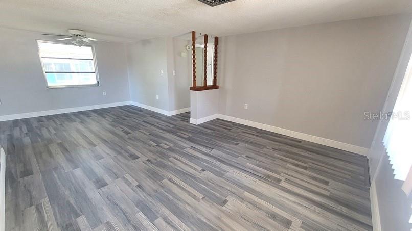9202 Suffolk Lane Port Richey, FL 34668 - Photo 5 of 20 an empty room with wooden floor and windows