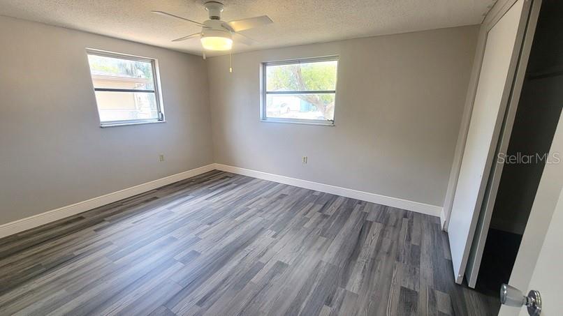 9202 Suffolk Lane Port Richey, FL 34668 - Photo 9 of 20 an empty room with wooden floor and windows