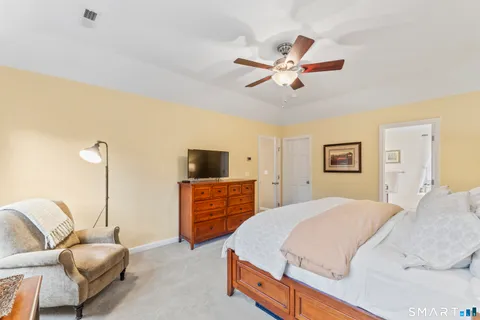 a bedroom with a bed a couch and a flat screen tv