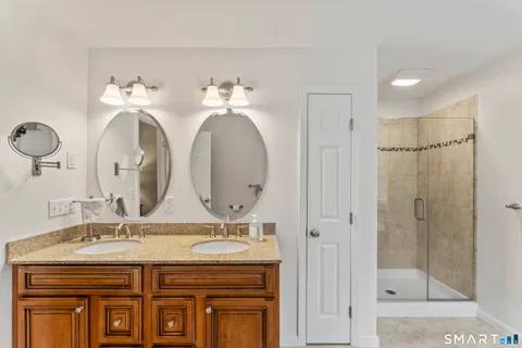 a bathroom with a granite countertop sink a mirror and a shower