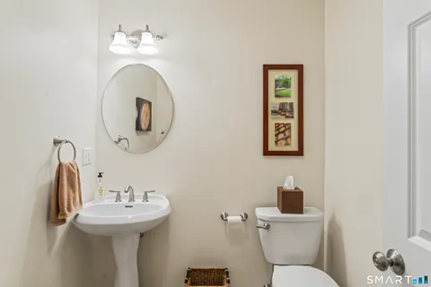 a bathroom with a toilet sink and mirror