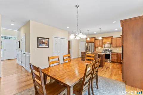 a dining room with furniture a chandelier and wooden floor