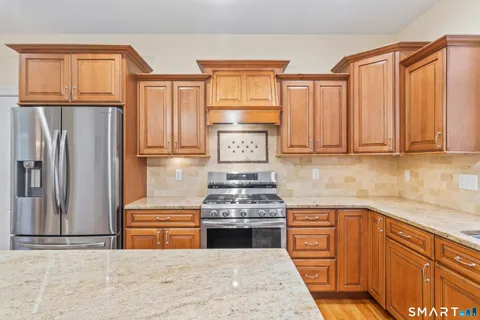 a kitchen with stainless steel appliances granite countertop a stove and a refrigerator