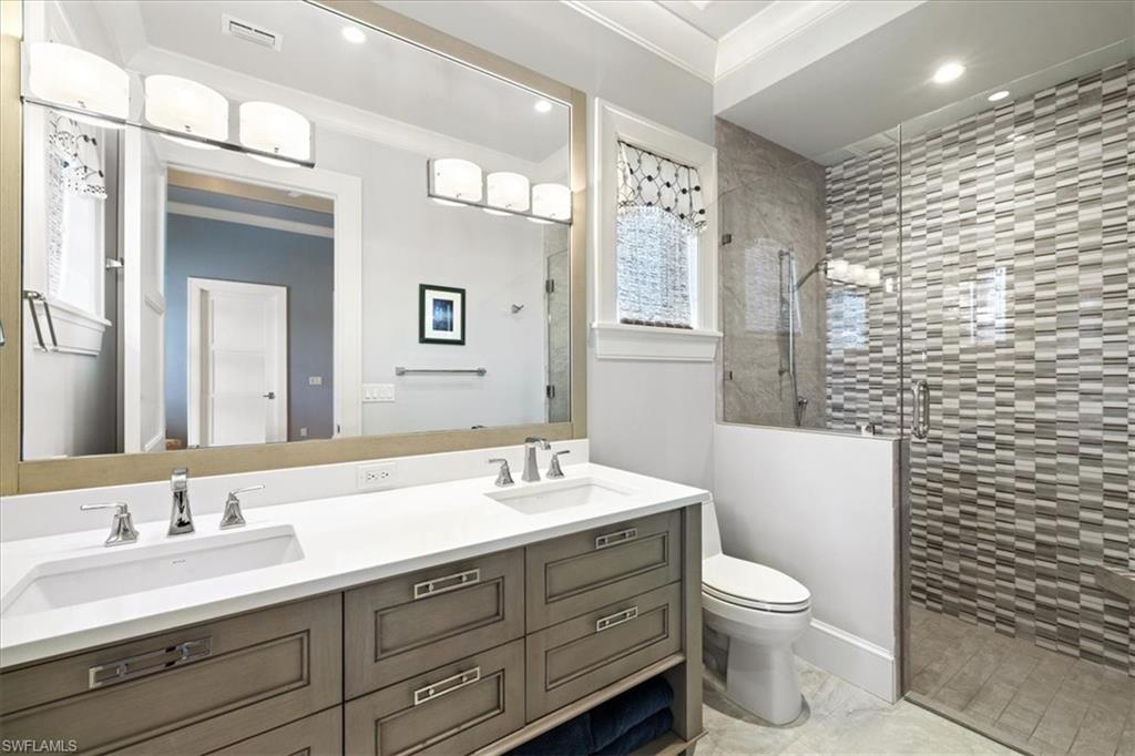 425 Harbour Drive Naples, FL 34103 - Photo 20 of 24 a bathroom with a double vanity sink toilet and a mirror