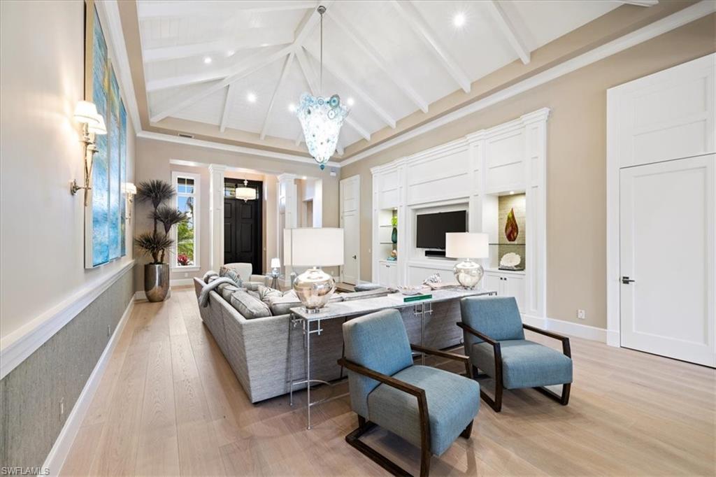 425 Harbour Drive Naples, FL 34103 - Photo 2 of 24 a living room with furniture chandelier and a flat screen tv