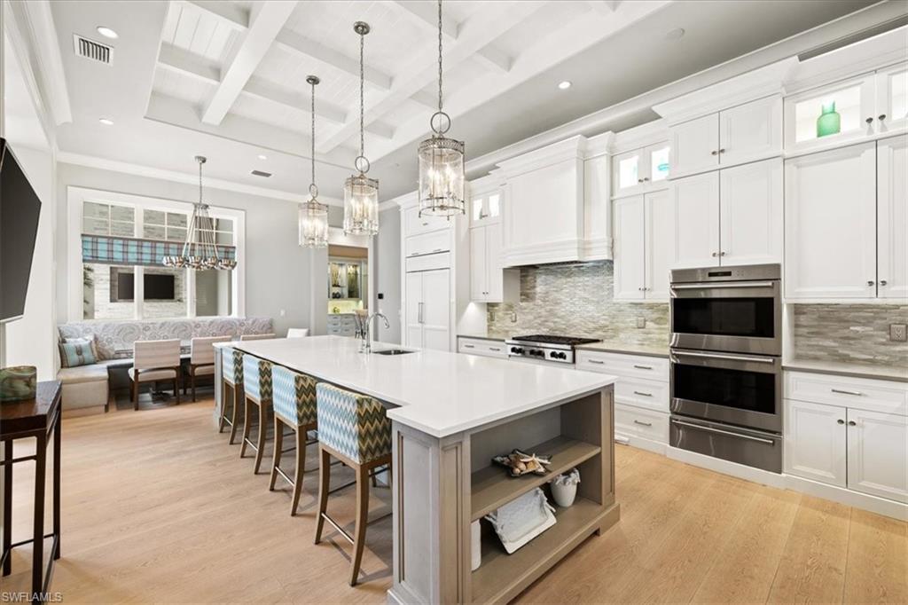 425 Harbour Drive Naples, FL 34103 - Photo 7 of 24 a large white kitchen with lots of counter space a sink appliances and dining table