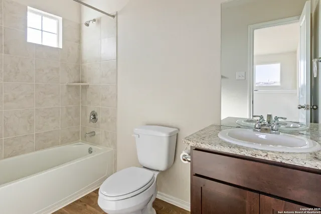 a bathroom with a granite countertop toilet a sink and a bathtub