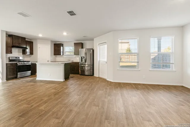 a view of kitchen with wooden floor and electronic appliances