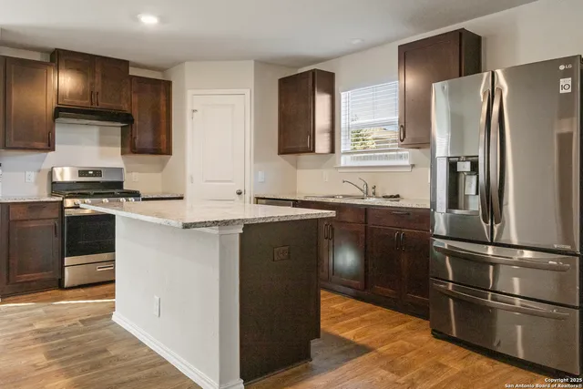 a kitchen with granite countertop stainless steel appliances and wooden cabinets