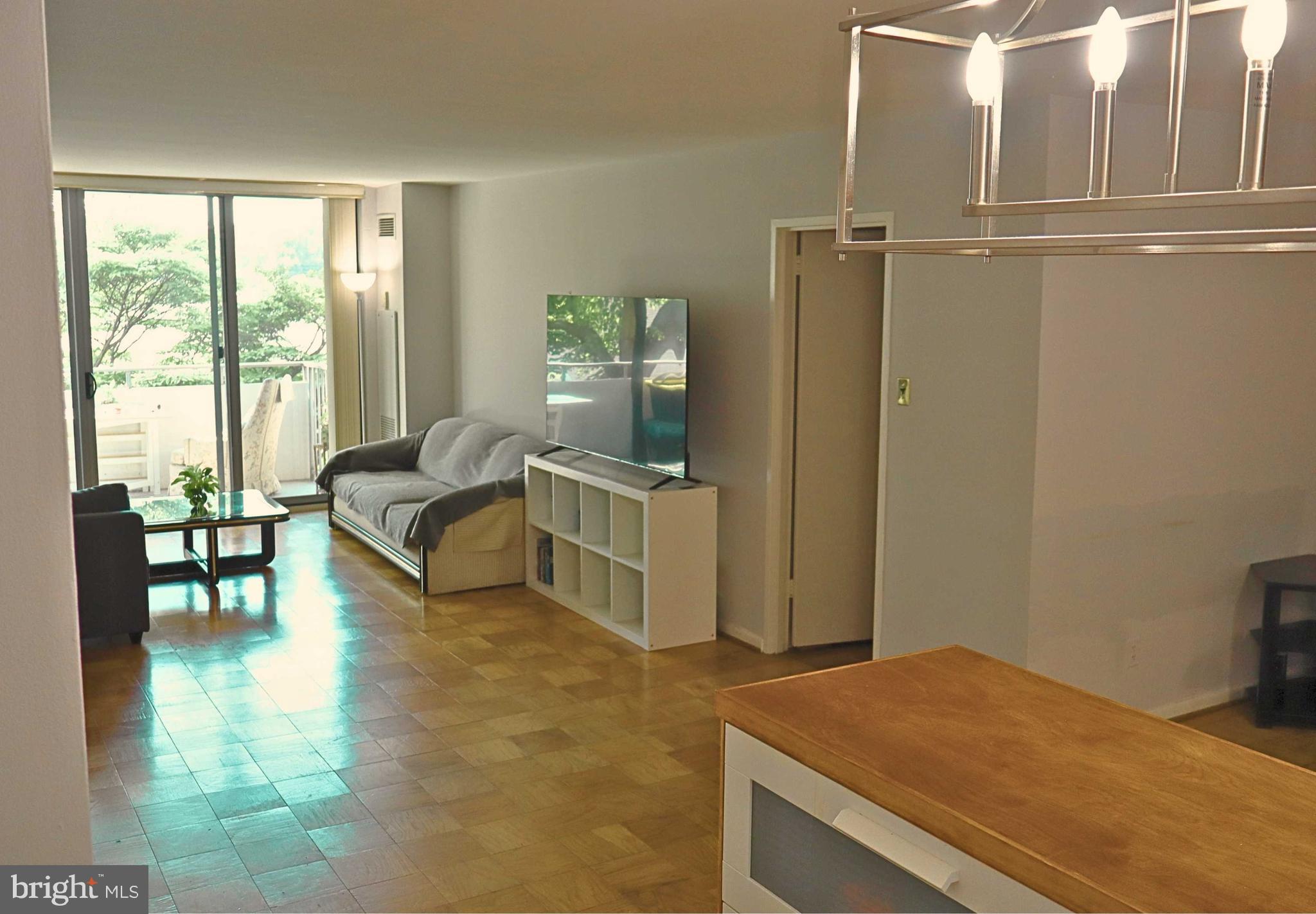 5101 River Road, Unit 405 Bethesda, MD 20816 - Photo 2 of 20 a bedroom with a bed and a view of living room
