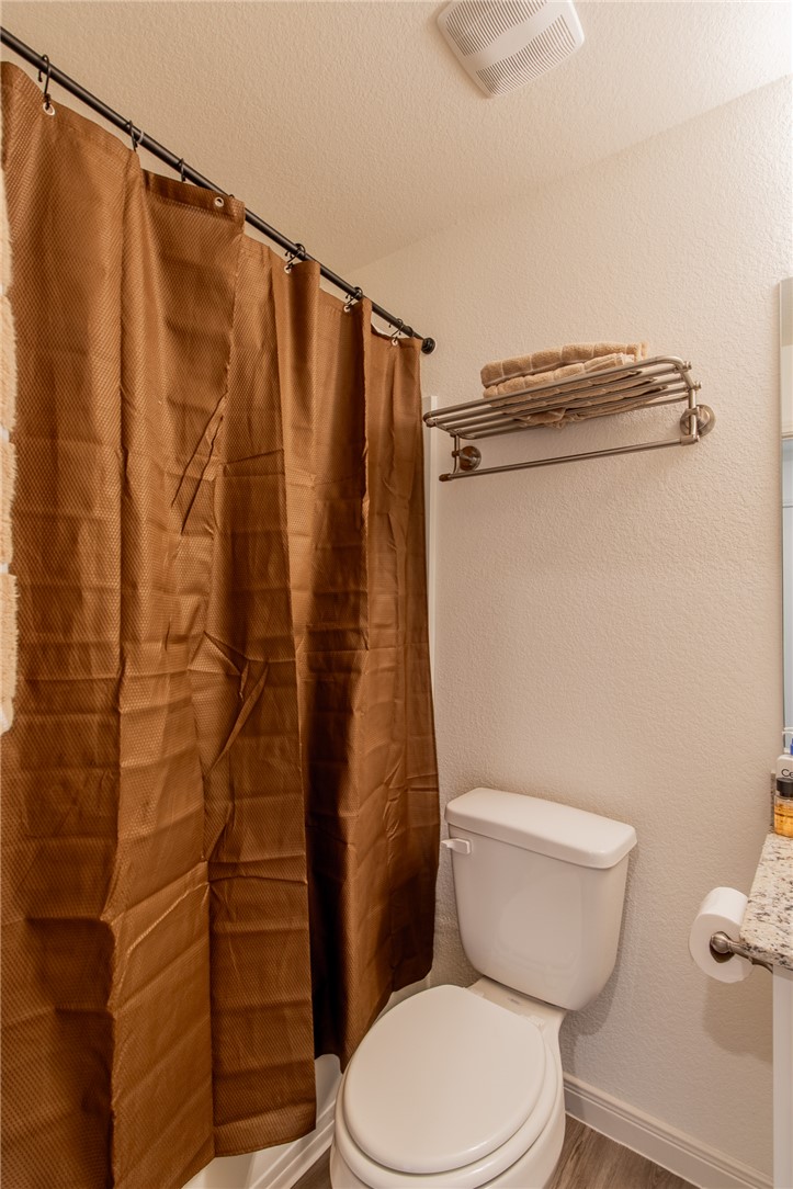 6029 Toby Bend Bryan, TX 77807 - Photo 10 of 25 a white toilet sitting next to a shower curtain