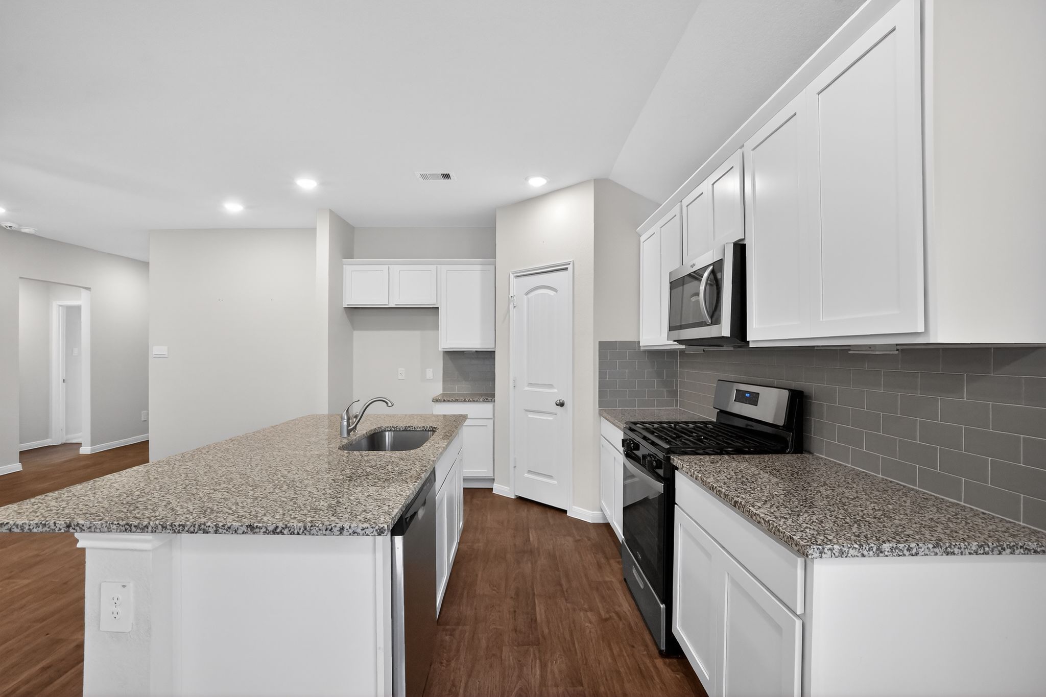 206 Addison Place Lockhart, TX 78644 - Photo 7 of 24 a kitchen with granite countertop kitchen island a sink stainless steel appliances and white cabinets