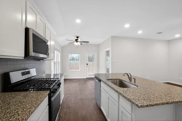 a kitchen with stainless steel appliances granite countertop a sink stove and refrigerator