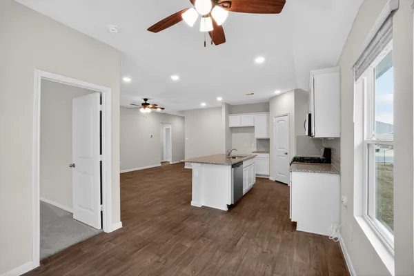 a kitchen with a refrigerator and white cabinets