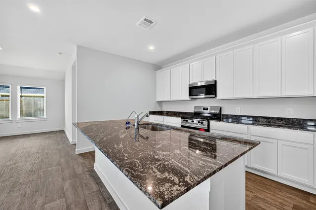 a kitchen with stainless steel appliances granite countertop a sink stove and microwave