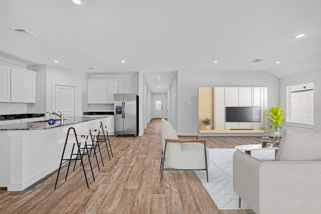 a living room with furniture and a wooden floor