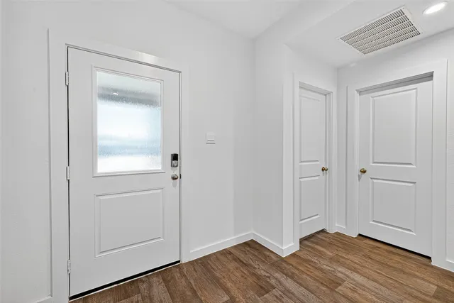 a view of an empty room with closet and a window