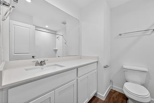 a bathroom with a toilet sink double vanity and mirror