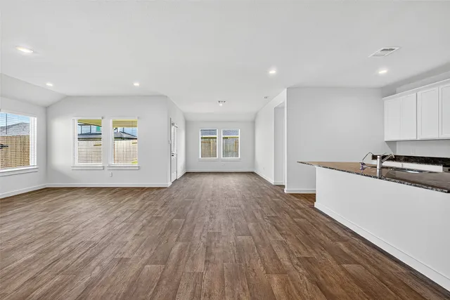 a view of a kitchen with wooden floor and electronic appliances