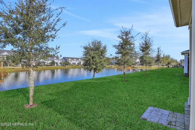 a view of an empty room with glass door and chandelier fan