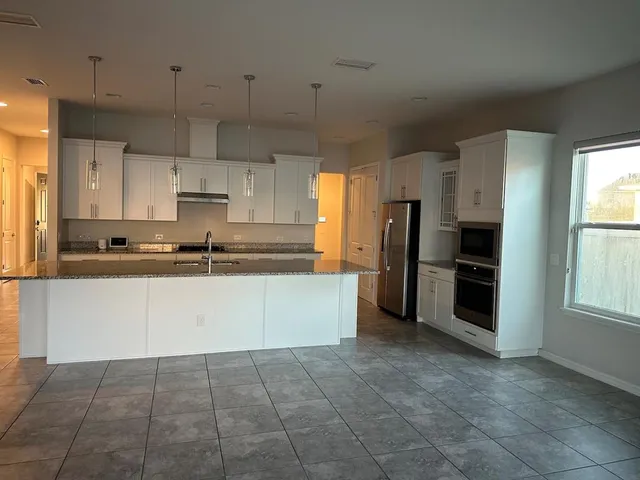 a kitchen with stainless steel appliances a refrigerator sink and microwave