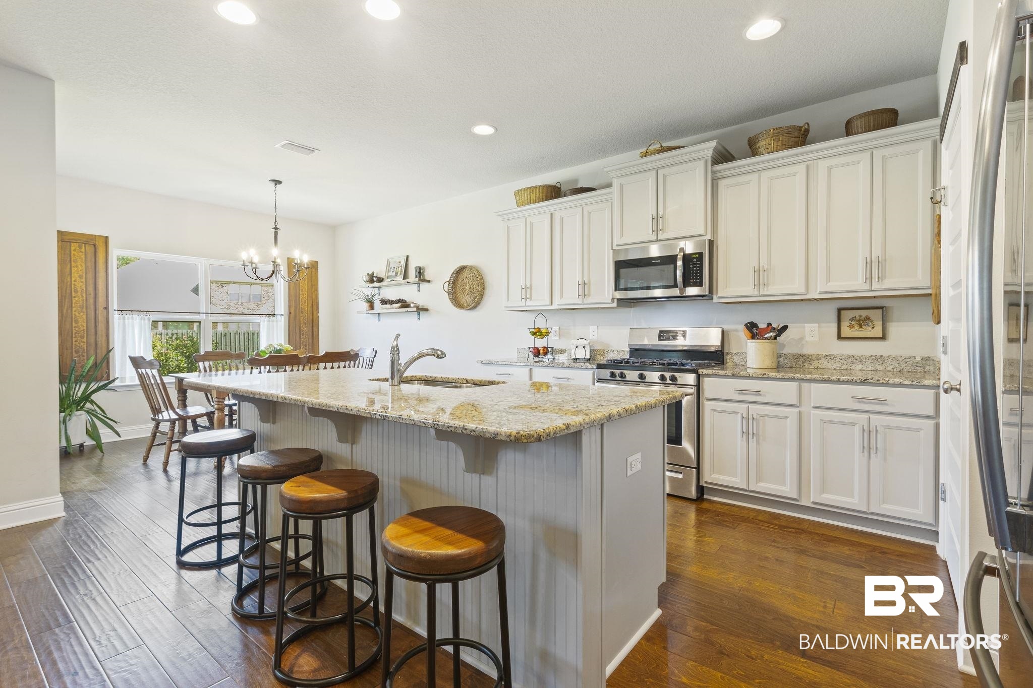 31663 Kestrel Loop Daphne, AL 36527 - Photo 20 of 86 Kitchen with appliances with stainless steel finishes, dark hardwood / wood-style floors, white cabinetry, and hanging light fixtures