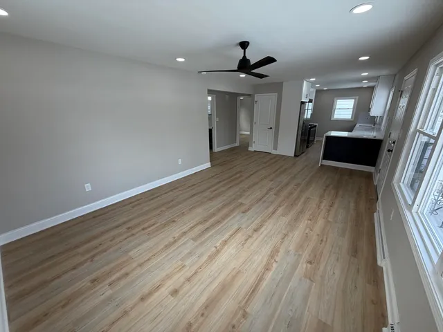 a view of empty room with wooden floor and window