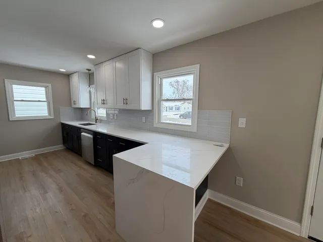 a kitchen with stainless steel appliances granite countertop a sink a stove a refrigerator and cabinets