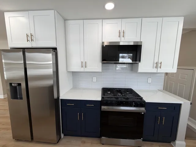 a kitchen with stainless steel appliances granite countertop a stove a refrigerator and a microwave
