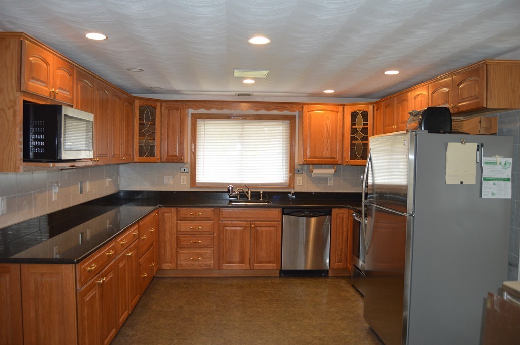 59 Joseph Road Framingham, MA 01701 - Photo 3 of 30 a kitchen with stainless steel appliances granite countertop a refrigerator a sink a stove and microwave