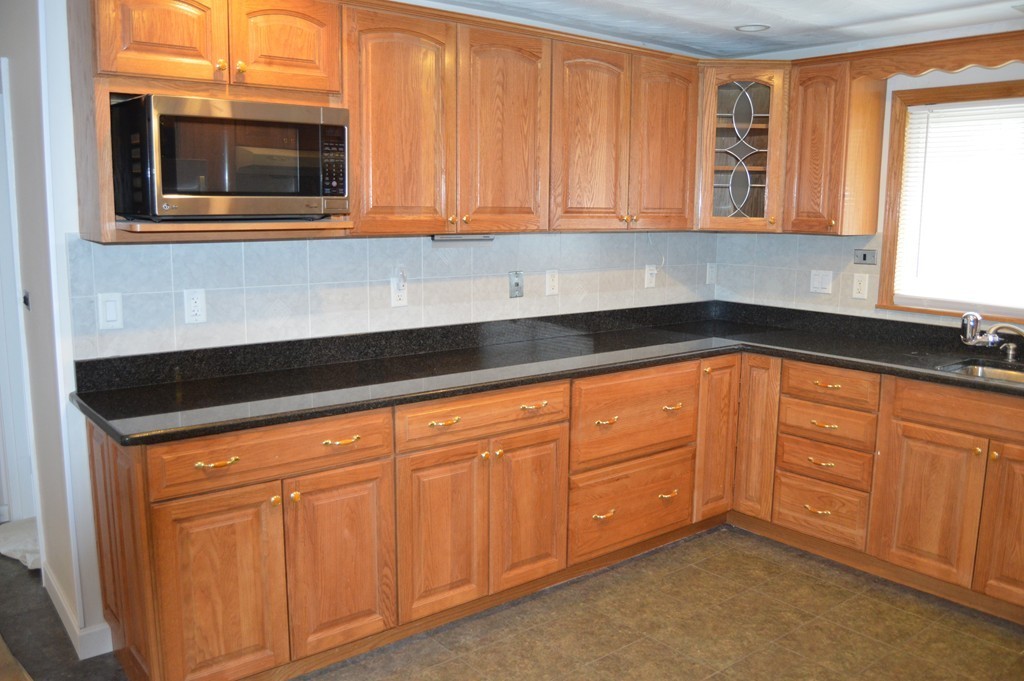 59 Joseph Road Framingham, MA 01701 - Photo 4 of 30 a kitchen with granite countertop white cabinets and stainless steel appliances