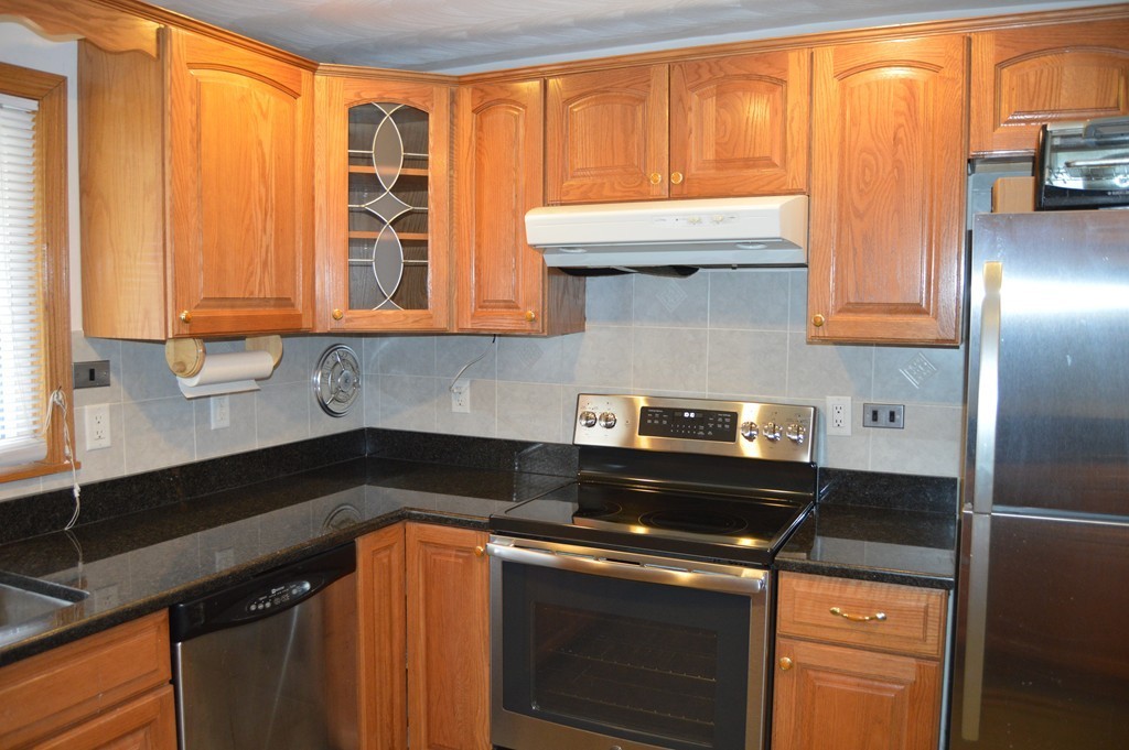 59 Joseph Road Framingham, MA 01701 - Photo 6 of 30 a kitchen with stainless steel appliances granite countertop a stove a sink and a microwave
