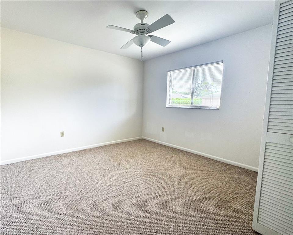 699 110th Avenue North, Unit A Naples, FL 34108 - Photo 6 of 15 an empty room with a window and a ceiling fan