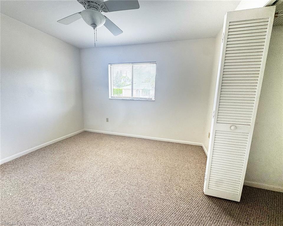 699 110th Avenue North, Unit A Naples, FL 34108 - Photo 7 of 15 wooden floor in an empty room with a window