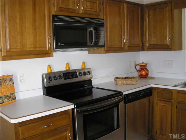 2654 Cottage Circle Raleigh, NC 27613 - Photo 4 of 17 a kitchen with stainless steel appliances a stove microwave and cabinets