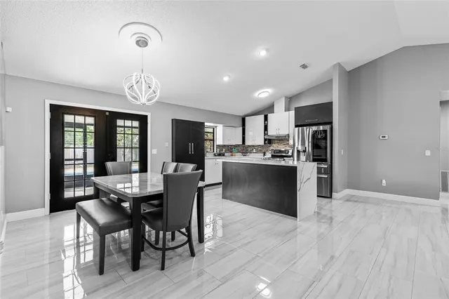 a kitchen with a dining table chairs wooden floor and appliances
